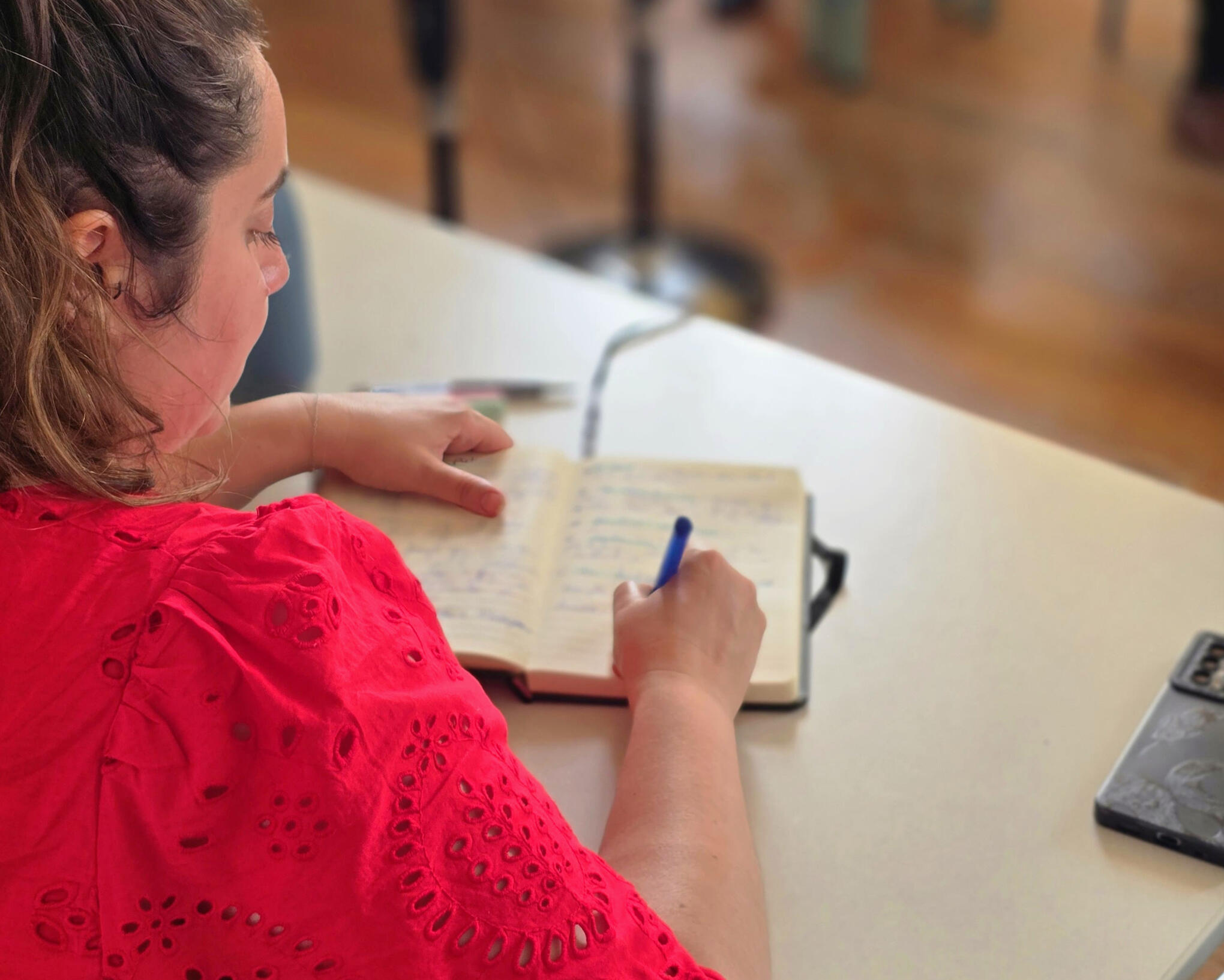 Formation la tribu du podcast, apprenante étant en train d'écrire sur son cahier